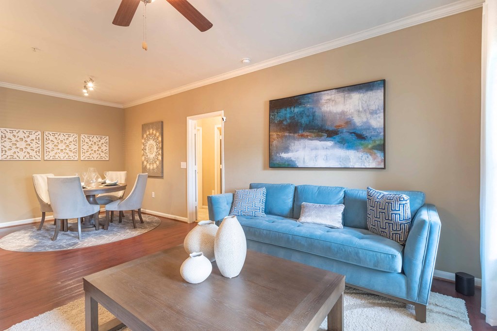 a living room with a blue couch and a coffee table at Century South Shore, League City, TX