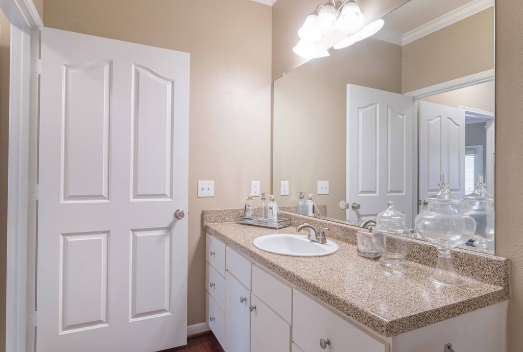 a bathroom with a sink and a mirror  at Century South Shore, League City, Texas