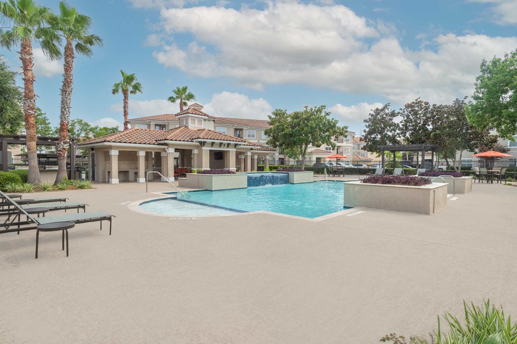 a swimming pool with a building in the background at Century South Shore, League City