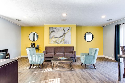 a living room with yellow walls and a couch and chairs
