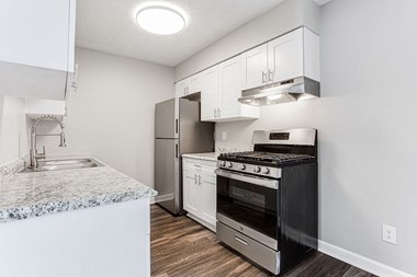 Kitchen with white cabinets and granite countertops at Chelsea Place apartments