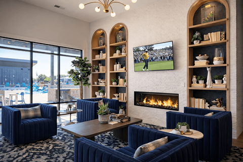 A living room with a fireplace and a television playing a football game.