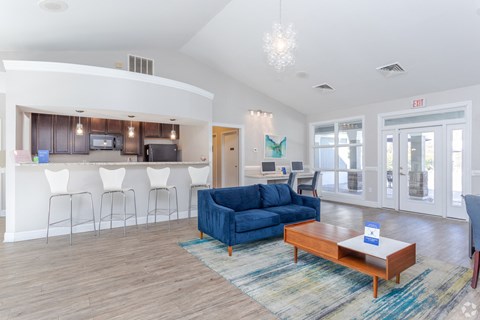 a living room and kitchen with a blue couch and a coffee table