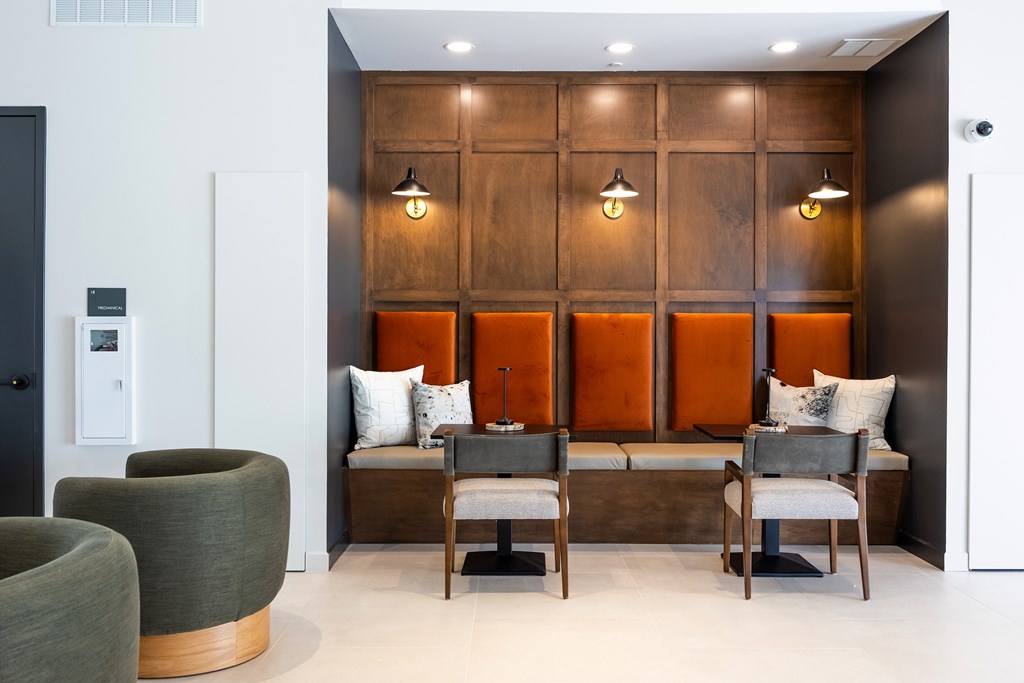 A room with a wooden panelled wall and a bench with cushions.