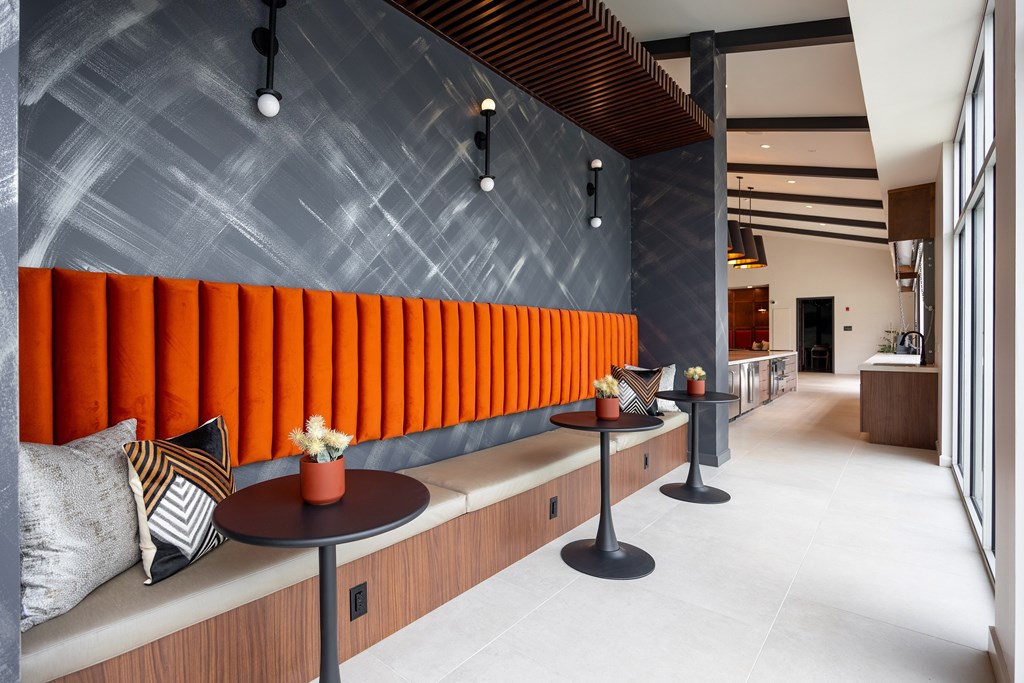 A modern dining area with a grey wall and orange striped wall.