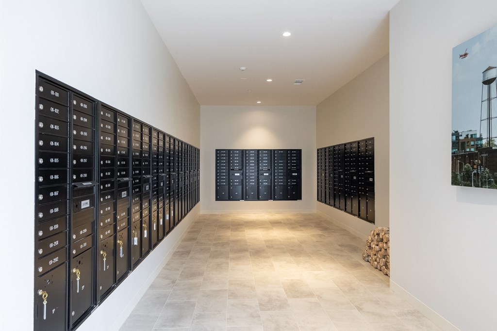 A long hallway with black lockers on the wall.