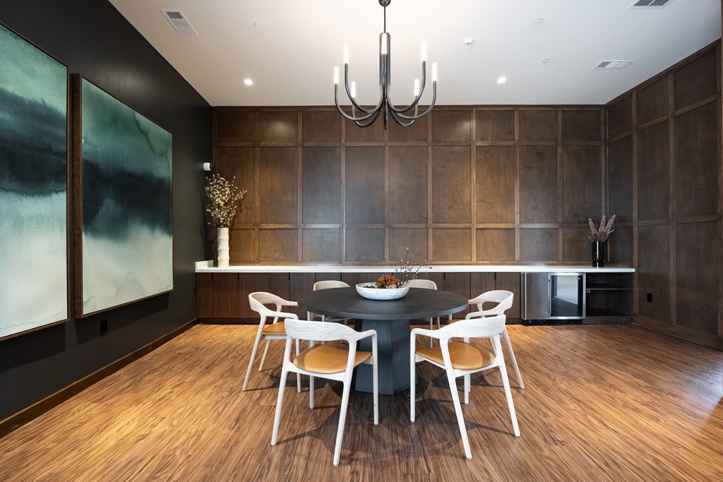 A modern dining room with a black table and chairs.