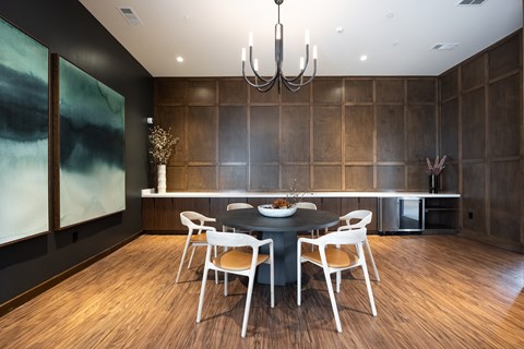 A modern dining room with a black table and chairs.