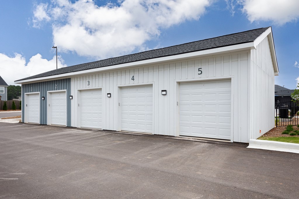 A white building with numbered garage doors.