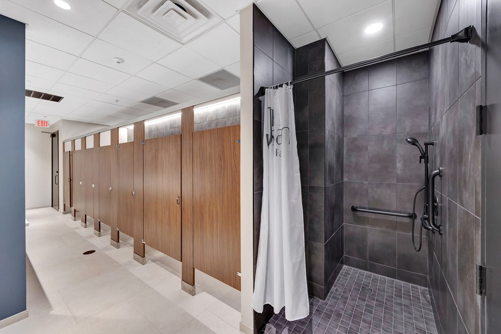 A row of wood stalls in a public restroom.