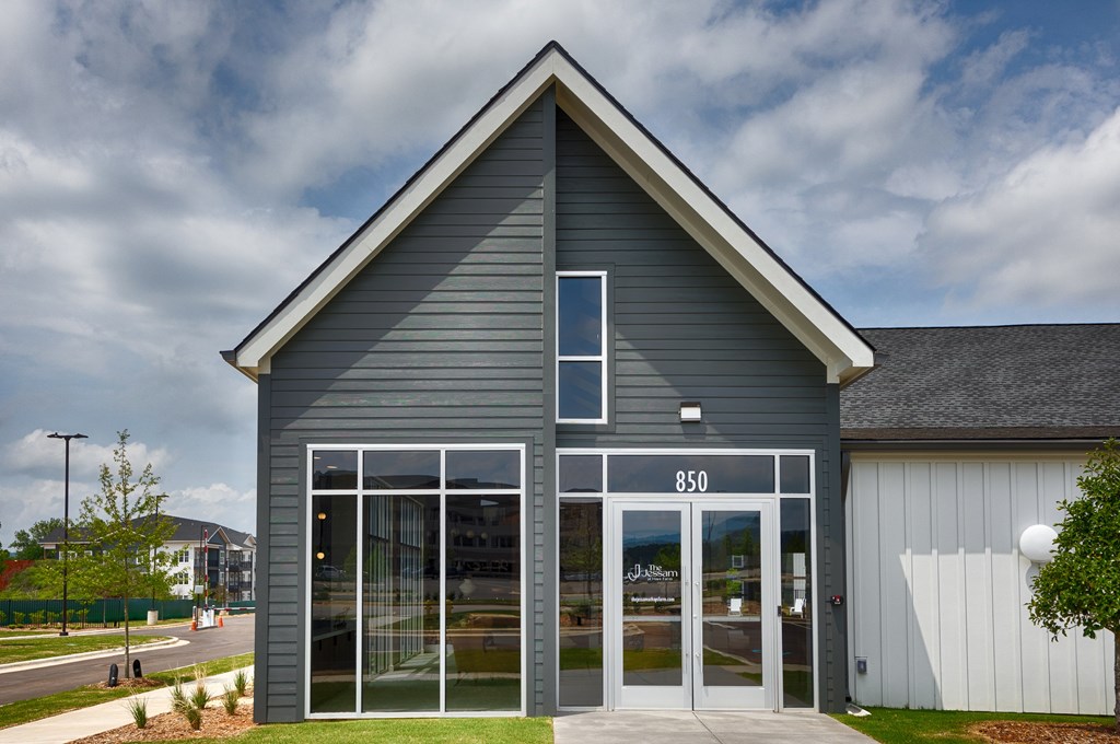 A modern building with a grey facade and a glass door.