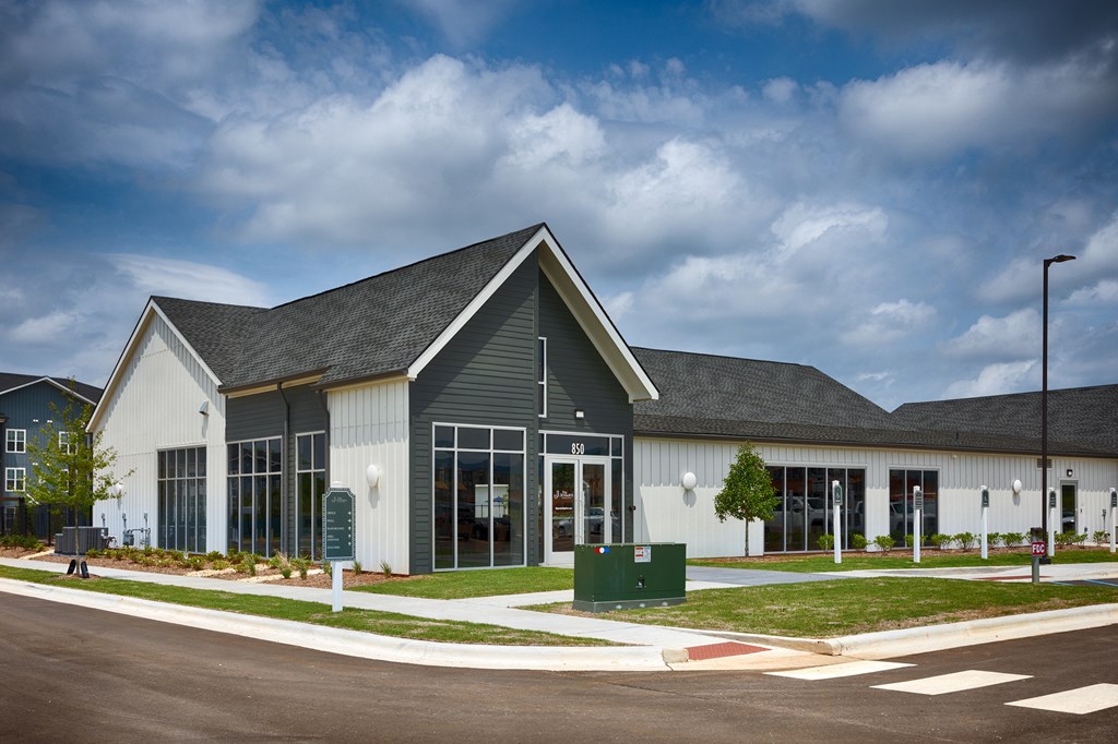 A modern building with a grey roof and white walls.