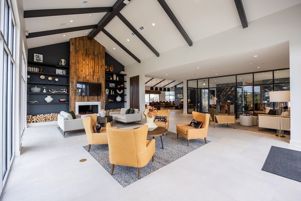 A modern living room with a wooden wall and a large rug.
