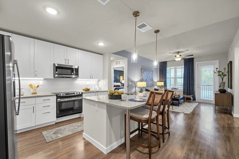 A modern kitchen with a large island and wooden floors.