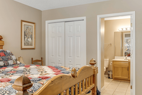 A bedroom with a bed, dresser, and mirror.