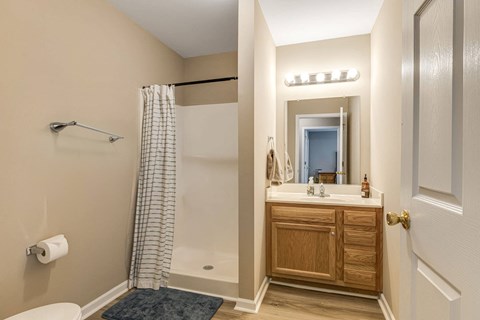 A bathroom with a toilet, sink, and shower.