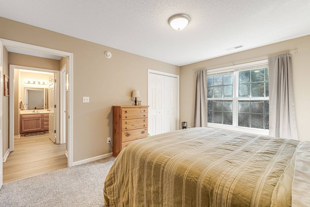A bedroom with a large bed and a dresser.