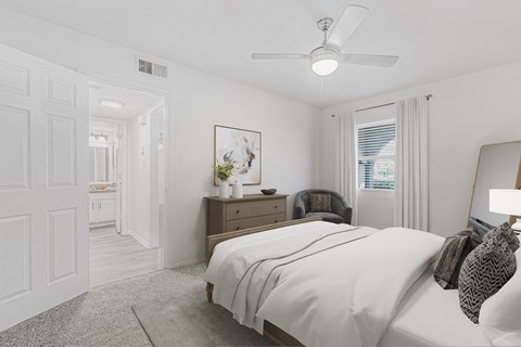 A bedroom with a bed, nightstand, and chair.