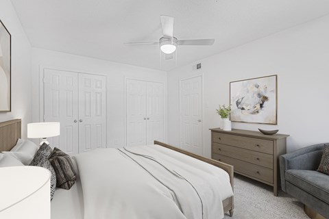 A bedroom with a bed, dresser, and couch.