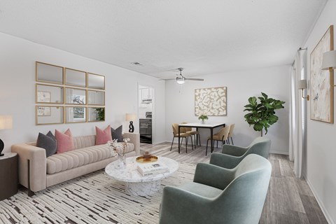A living room with a grey sofa, a coffee table, and a dining table with chairs.