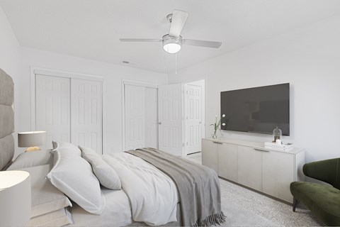 A bedroom with a bed, a television, and a green chair.