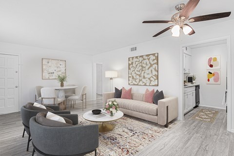 A living room with a grey couch, a coffee table, and a ceiling fan.