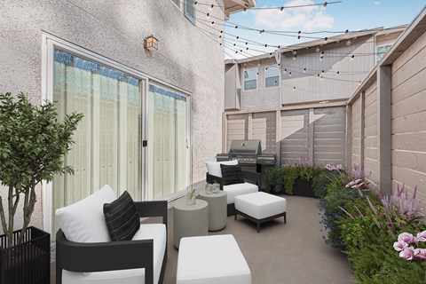 A patio with a white couch, a black tree, and a white table.