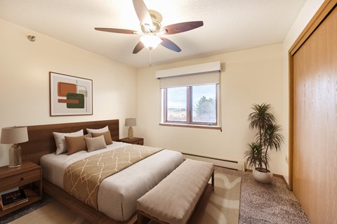 A bedroom with a large bed and a ceiling fan.