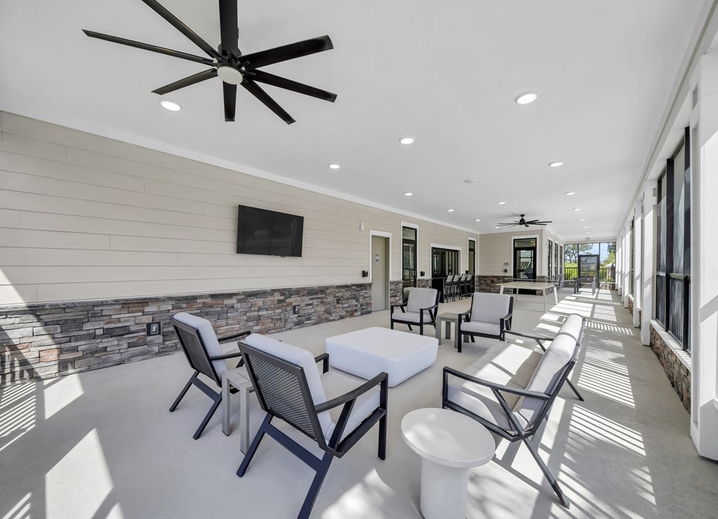 a patio with chairs and tables and a ceiling fan