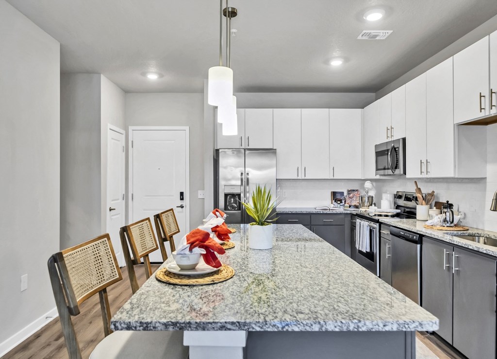 a kitchen with white cabinets and stainless steel appliances