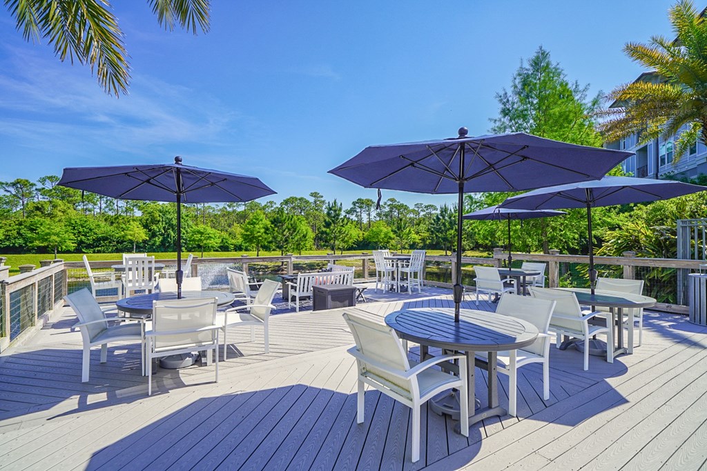 a patio with tables and chairs and umbrellas