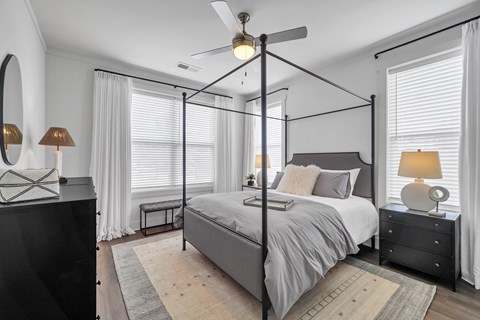 a bedroom with a large bed and two windows at The Indigo Apartments, Canton, GA, 30114