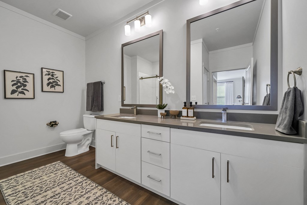 a bathroom with white cabinets and a large mirror at The Indigo Apartments, Canton, GA, 30114