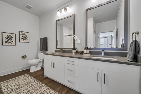 a bathroom with white cabinets and a large mirror at The Indigo Apartments, Canton, GA, 30114