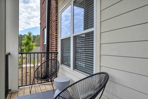 a balcony with two chairs and a table at The Indigo Apartments, Canton