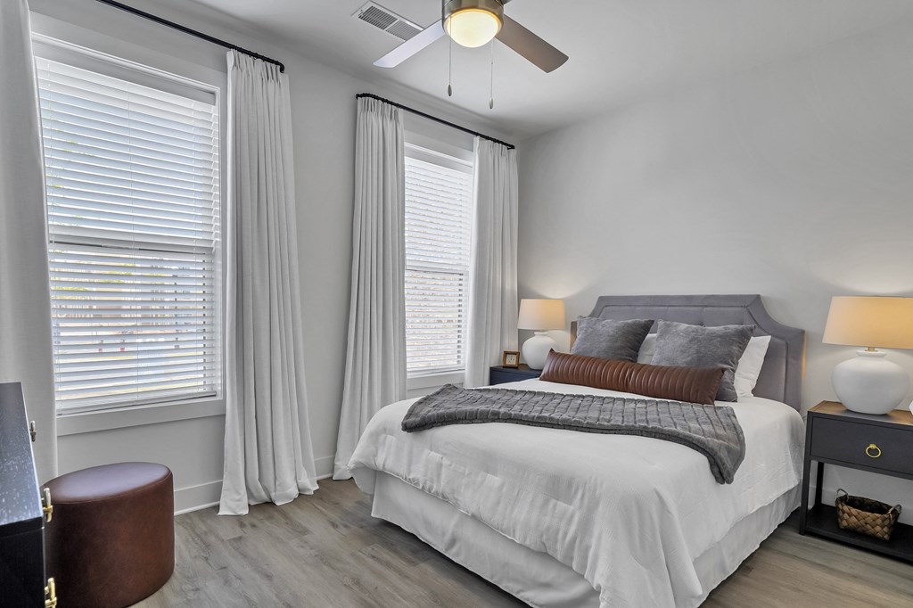 a bedroom with a bed and two windows  at The Landing on Summers Street, Kennesaw, Georgia