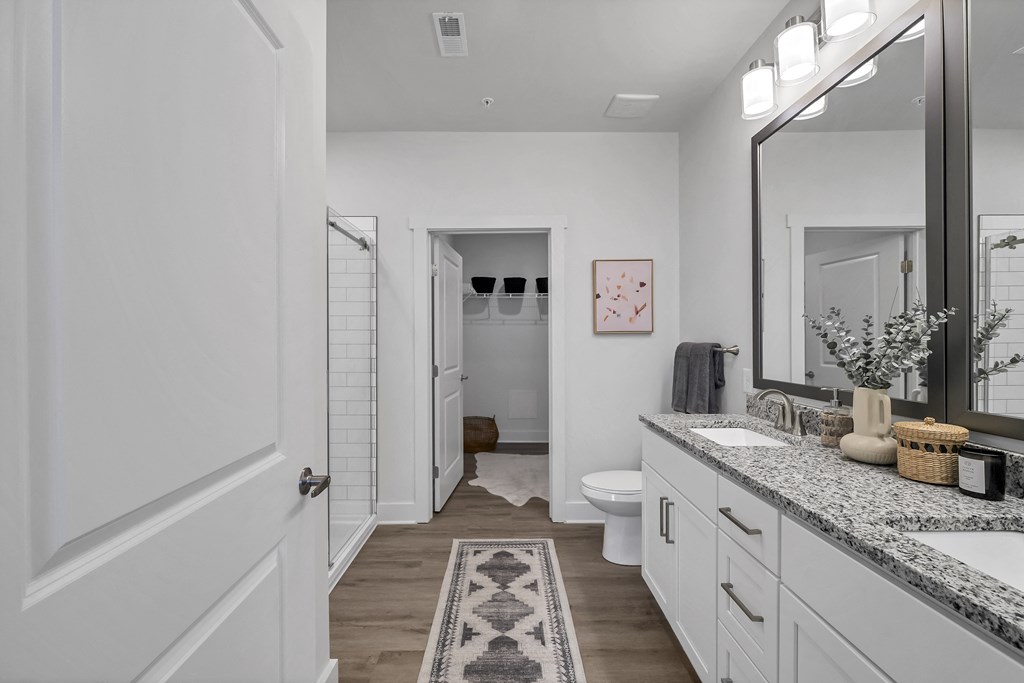 a bathroom with a large mirror and two sinks at The Landing on Summers Street Apartments, Georgia, 30144