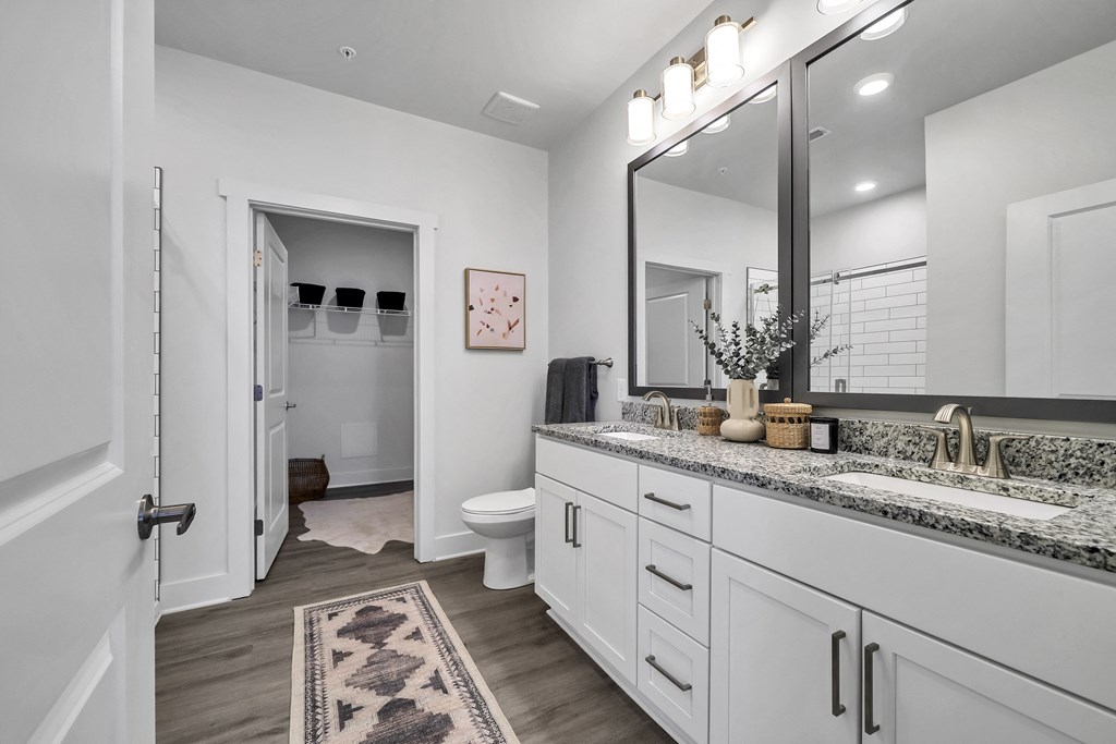 a bathroom with white cabinetry and a large mirror  at The Landing on Summers Street, Georgia