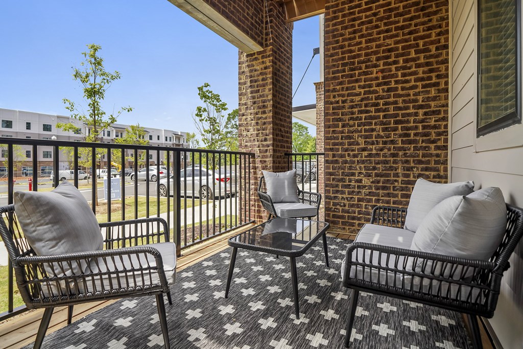 a balcony with two chairs and a coffee table  at The Landing on Summers Street, Kennesaw