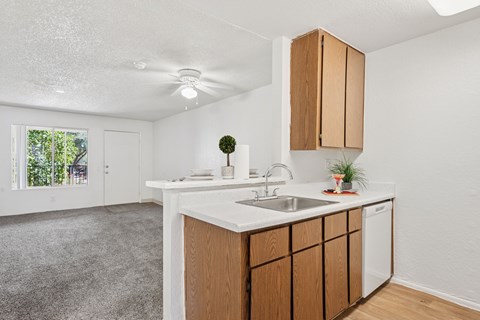 A kitchen with a white counter top and wooden cabinets.