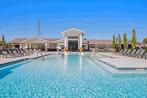 Resort-style swimming pool for residents to enjoy surrounded by lounge chairs and pergolas.