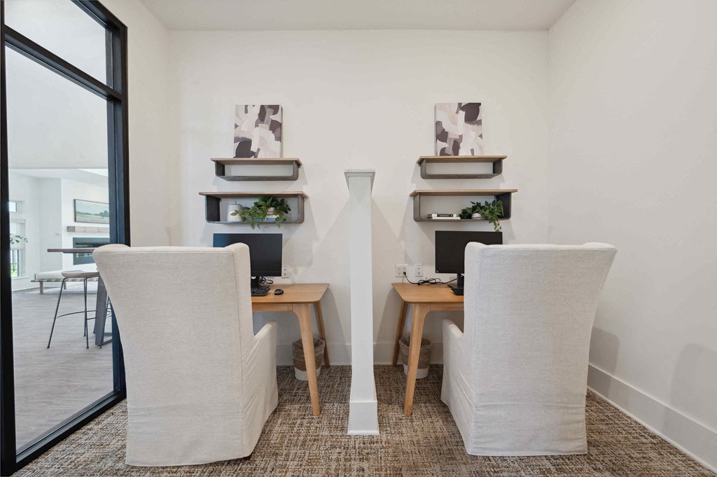 a conference room with two chairs and a desk with a computer