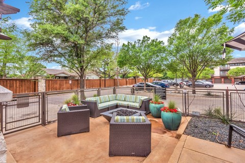 A patio with a table and chairs surrounded by a fence.