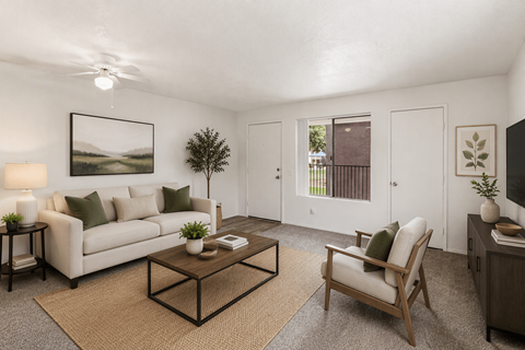 A living room with a white couch, a coffee table, and a painting on the wall.