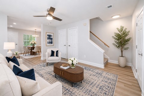 A living room with a white couch, a coffee table, and a ceiling fan.