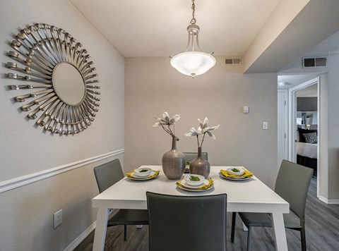 A dining room with a white table and chairs.