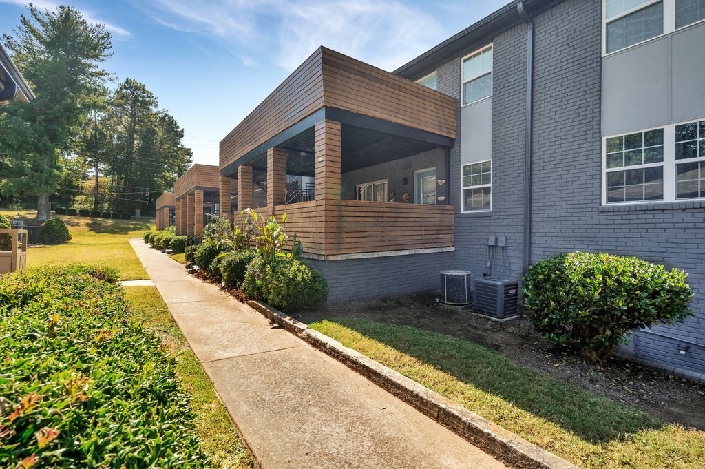 a sidewalk in front of a building with a porch