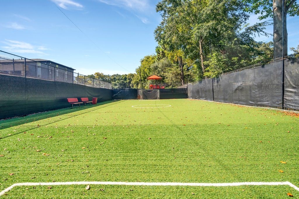 a soccer field with a goal in the middle of a fence