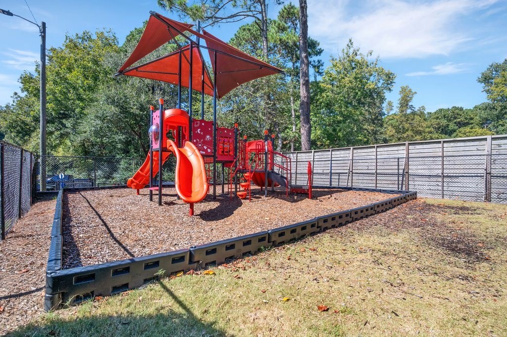 a playground with a swing set and slides in a park