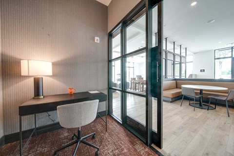 a conference room with glass doors and a desk with a chair